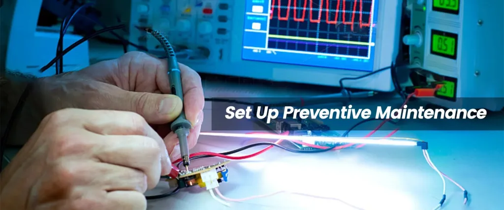 Close-up of hands testing an illuminated LED circuit with a probe, against a backdrop of test equipment. Header Set Up Preventive Maintenance